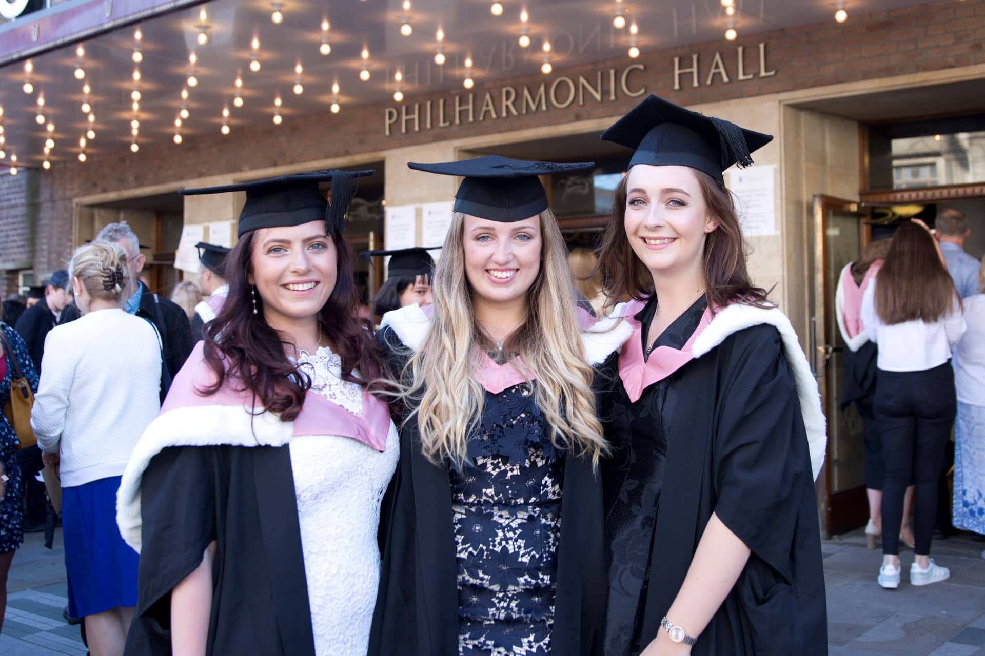 Students at graduation smiling at camera