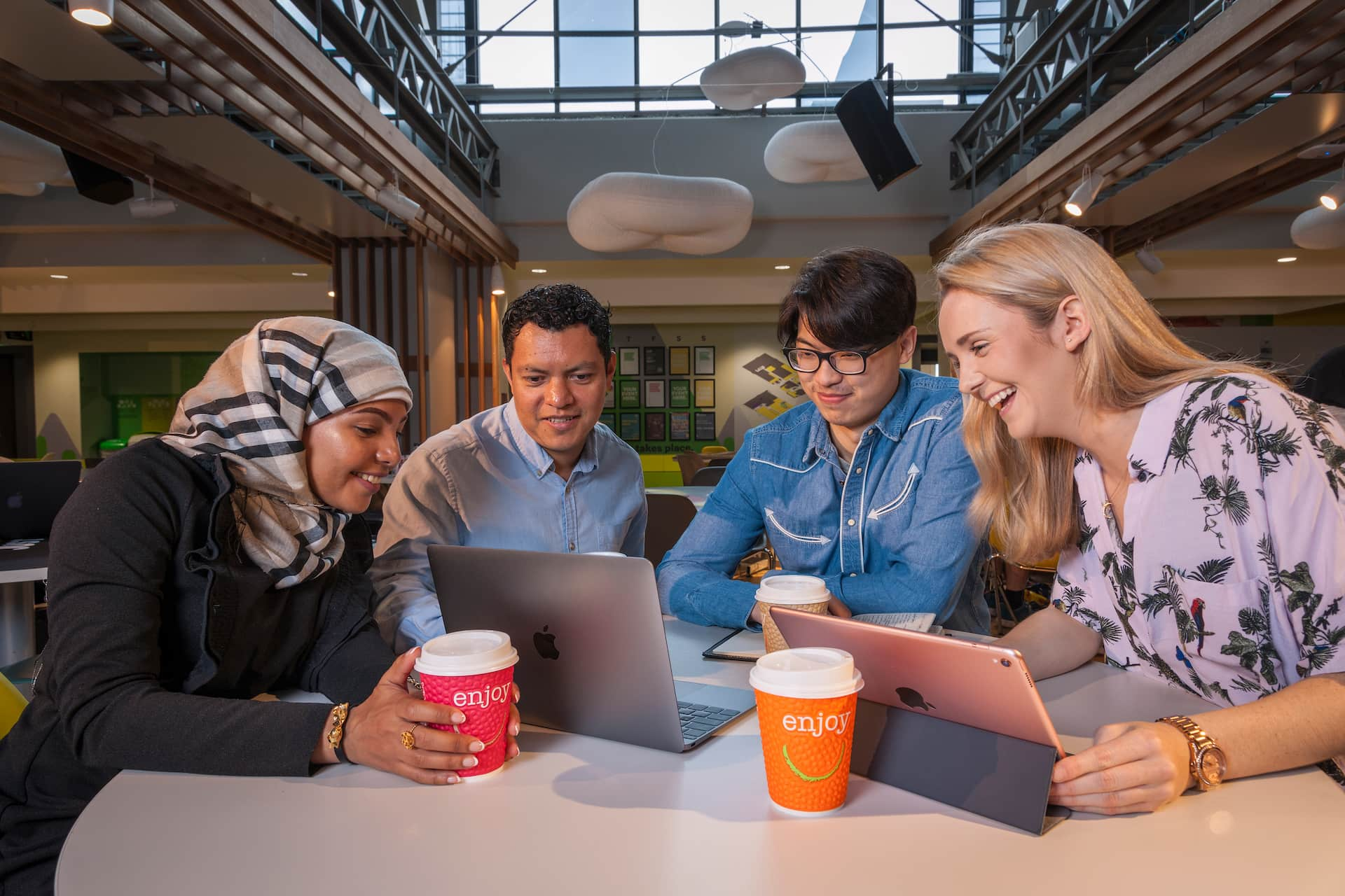 Postgraduate students chatting at table in Guild of Students